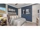 Cozy bedroom featuring a blue accent wall, neutral carpet, crown moulding, and decorative artwork at 3415 Lumber Falls Dr, Plant City, FL 33565