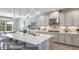Well-equipped kitchen features an island with seating, pendant lighting, and stainless steel appliances at 3415 Lumber Falls Dr, Plant City, FL 33565
