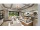 Open concept living room and kitchen area with hardwood floors, large sliding glass doors, and elegant furnishings at 3415 Lumber Falls Dr, Plant City, FL 33565