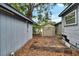 Backyard featuring small shed, trees, and damaged deck at 4102 Haines N Rd, St Petersburg, FL 33703