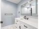 Well-lit powder room featuring a marble floor, vanity with sleek hardware, contemporary faucet, and stylish mirror at 4307 Woodfield Ave, Holiday, FL 34691
