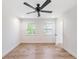 Bright, empty bedroom with hardwood floors, a ceiling fan, and natural light streaming in through the windows at 4307 Woodfield Ave, Holiday, FL 34691
