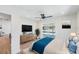 Bright bedroom with a large TV, light wood floors, and sliding glass doors leading to a pool at 4307 Woodfield Ave, Holiday, FL 34691