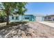 Charming single-story home featuring a light blue exterior, well-maintained lawn, and a driveway leading to an attached garage at 4307 Woodfield Ave, Holiday, FL 34691