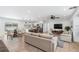 Bright, open-concept living space with hardwood floors and a modern kitchen featuring stainless steel appliances and a breakfast bar at 4307 Woodfield Ave, Holiday, FL 34691