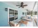 Covered outdoor patio featuring comfortable seating, ceiling fans, and access to a screened pool area at 4307 Woodfield Ave, Holiday, FL 34691
