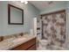 Well-lit bathroom featuring a granite vanity, framed mirror, and a shower-tub combo with floral shower curtain at 4722 Millpond Ln, Tampa, FL 33624