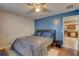 Comfortable bedroom features a modern bed, ceiling fan, and access to an adjacent kitchen area at 4722 Millpond Ln, Tampa, FL 33624