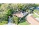 A close aerial view of a property featuring a screened-in pool area and mature palm trees at 50 Pembrook Cir, Palm Harbor, FL 34683