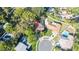 Aerial view of a home nestled among lush greenery, showcasing the backyard pool and proximity to neighboring houses at 50 Pembrook Cir, Palm Harbor, FL 34683