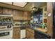 A classic kitchen featuring wood cabinetry, a double sink, and ample counter space with vintage appliances at 50 Pembrook Cir, Palm Harbor, FL 34683