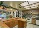 Warm kitchen with wooden cabinets, an island, and decorative ivy accents for a cozy, vintage feel at 50 Pembrook Cir, Palm Harbor, FL 34683