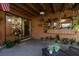 Covered patio with ample seating, potted plants, and sliding glass doors to interior at 50 Pembrook Cir, Palm Harbor, FL 34683