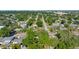 An aerial view of a quiet neighborhood surrounded by lush green trees and clear blue skies at 5302 S Himes Ave, Tampa, FL 33611