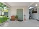 The backyard entrance on the covered porch leads to a grassy, well-kept backyard and shed at 5302 S Himes Ave, Tampa, FL 33611