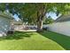 Well-maintained backyard featuring a lush lawn, outdoor dining, grill and privacy fence at 5302 S Himes Ave, Tampa, FL 33611