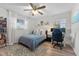 Cozy bedroom features a ceiling fan, wood floors, and a dedicated workspace by the window at 5302 S Himes Ave, Tampa, FL 33611