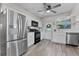 The kitchen features stainless steel appliances, white cabinets, and wood-look vinyl flooring at 5302 S Himes Ave, Tampa, FL 33611