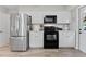 The kitchen features stainless steel appliances, white cabinetry, and an adjoining door to the outside at 5302 S Himes Ave, Tampa, FL 33611