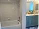A view of a shower next to a bathroom vanity with double sinks and white tile at 5915 Sea Ranch Dr # 512, Hudson, FL 34667