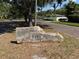Stone sign that reads Lake Pasadena Estates, with mature trees lining the street at 6345 Dartmouth N Ave, St Petersburg, FL 33710