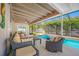 The covered patio features comfortable wicker furniture, seating, and a clear view of the pool at 6345 Dartmouth N Ave, St Petersburg, FL 33710