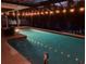 Backyard pool and patio area are illuminated at night by string lights at 6345 Dartmouth N Ave, St Petersburg, FL 33710