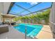 Sparkling pool surrounded by a screened enclosure and patio seating and lounging areas at 6345 Dartmouth N Ave, St Petersburg, FL 33710