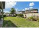 Spacious backyard features lush lawn, a playhouse, garden beds, and perimeter fence at 6477 Dutton Dr, Wesley Chapel, FL 33545