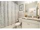 Bright bathroom with granite vanity, patterned shower curtain and decorative accents at 6477 Dutton Dr, Wesley Chapel, FL 33545
