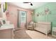 Bright Bedroom with soft pink walls, pale green accents, and a white crib and decor at 6477 Dutton Dr, Wesley Chapel, FL 33545