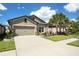 Well-maintained home boasts a two-car garage, neat landscaping, and a spacious concrete driveway at 6477 Dutton Dr, Wesley Chapel, FL 33545