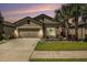 Charming home featuring a two-car garage, beautiful landscaping, and a well-maintained lawn at 6477 Dutton Dr, Wesley Chapel, FL 33545