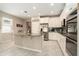 The bright kitchen features stainless steel appliances, a central island with granite countertops at 6477 Dutton Dr, Wesley Chapel, FL 33545