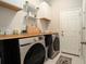 Well-organized laundry room with Samsung washer and dryer and ample countertop space at 6477 Dutton Dr, Wesley Chapel, FL 33545