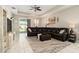 Spacious living room featuring a ceiling fan, tile flooring, and sliding glass doors to backyard at 6477 Dutton Dr, Wesley Chapel, FL 33545