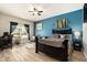 Bright main bedroom features wood-look floors, ceiling fan, an accent wall, and a desk area at 6477 Dutton Dr, Wesley Chapel, FL 33545