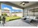 Covered patio with neutral wicker furniture, a ceiling fan, and a view of the green backyard at 6477 Dutton Dr, Wesley Chapel, FL 33545