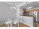 A modern kitchen with wooden cabinets and stainless steel appliances is adjacent to a dining area with glass table and chairs at 700 S Harbour Island Blvd # 547, Tampa, FL 33602