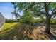 Lush backyard featuring mature trees, green grass, and a charming seating area at 7288 Castleberry Ter, Englewood, FL 34224