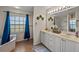 Bright bathroom with double vanity, a large mirror with modern lighting, and a garden tub at 7288 Castleberry Ter, Englewood, FL 34224
