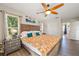 Bright bedroom featuring a wood-frame bed, ceiling fan, and a window with natural light at 7288 Castleberry Ter, Englewood, FL 34224