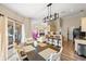 Open dining area with modern lighting, a kitchen bar, and a view to the outdoor patio at 7288 Castleberry Ter, Englewood, FL 34224