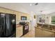 Bright open kitchen featuring granite countertops, black appliances, and view to dining area at 7288 Castleberry Ter, Englewood, FL 34224
