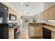 Bright open kitchen with granite countertops, wood cabinets, and stainless steel sink at 7288 Castleberry Ter, Englewood, FL 34224