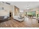 Spacious living room featuring wood-look floors, white couch, and view of the screened lanai at 7288 Castleberry Ter, Englewood, FL 34224