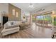 Open living room featuring wood-look floors, sliding doors to the lanai, and comfortable seating at 7288 Castleberry Ter, Englewood, FL 34224
