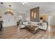 Open-concept living room with wood floors, white sectional sofa, and modern decor at 7288 Castleberry Ter, Englewood, FL 34224