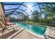 A picturesque screened-in pool with outdoor seating, perfect for enjoying sunny days at 7288 Castleberry Ter, Englewood, FL 34224