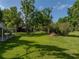 Expansive backyard featuring mature trees and a view of the screened-in enclosure at 7508 W Short Rd, Plant City, FL 33565